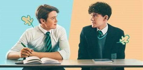 Netflix Heartstopper Key Art Charlie and Nick are looking at each other, sitting at a school desk in their uniforms