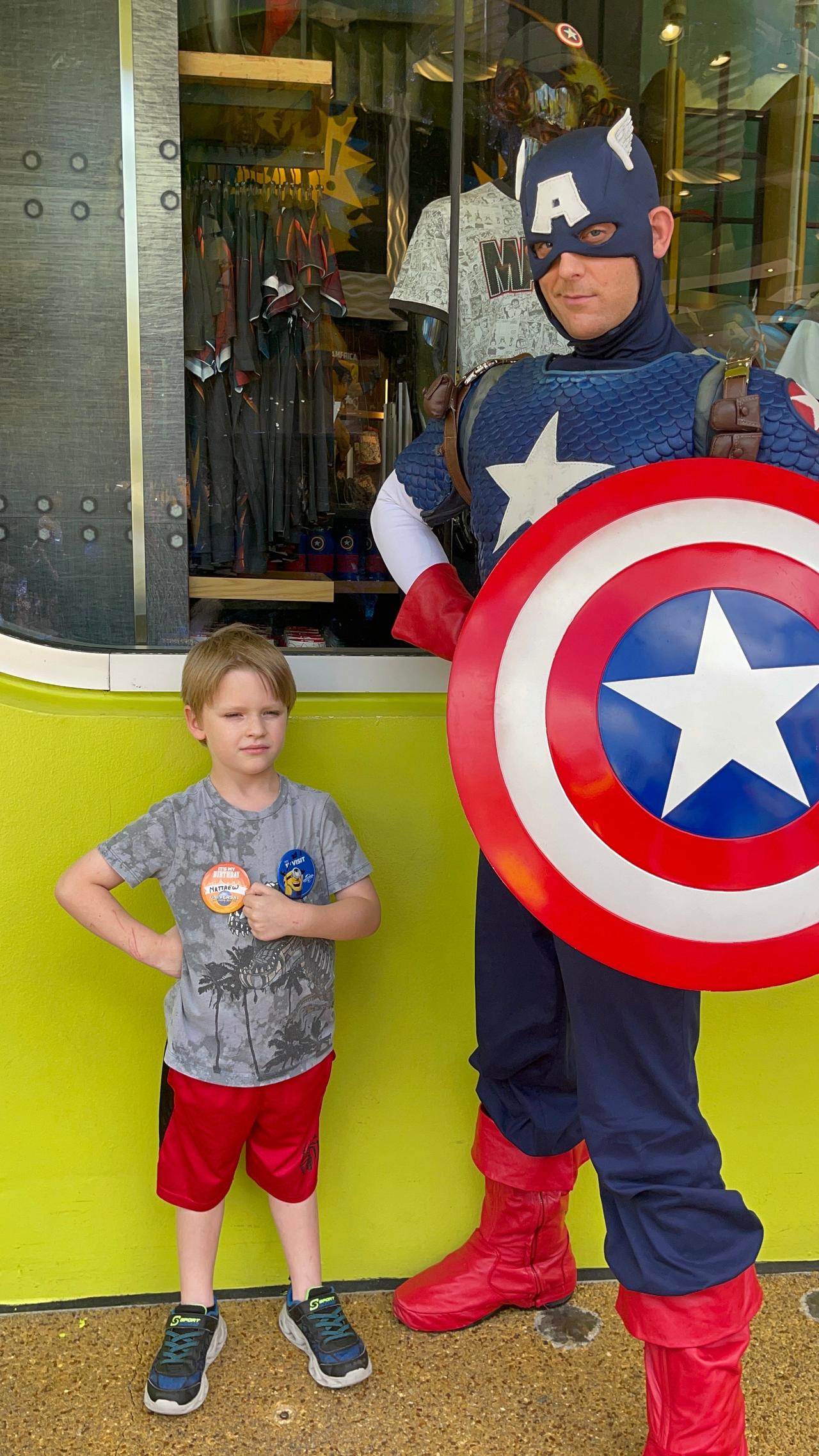 A boy poses with a Captain America character actor