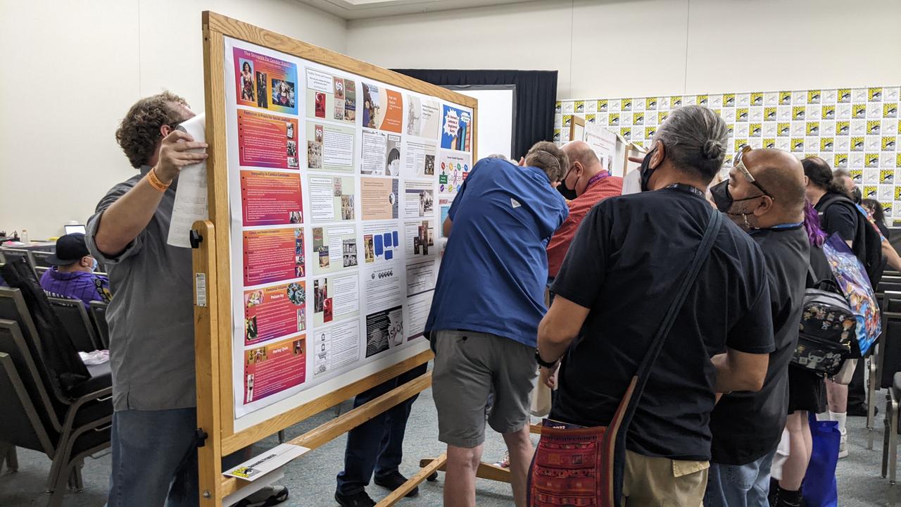 A small crowd of people in front of an academic poster