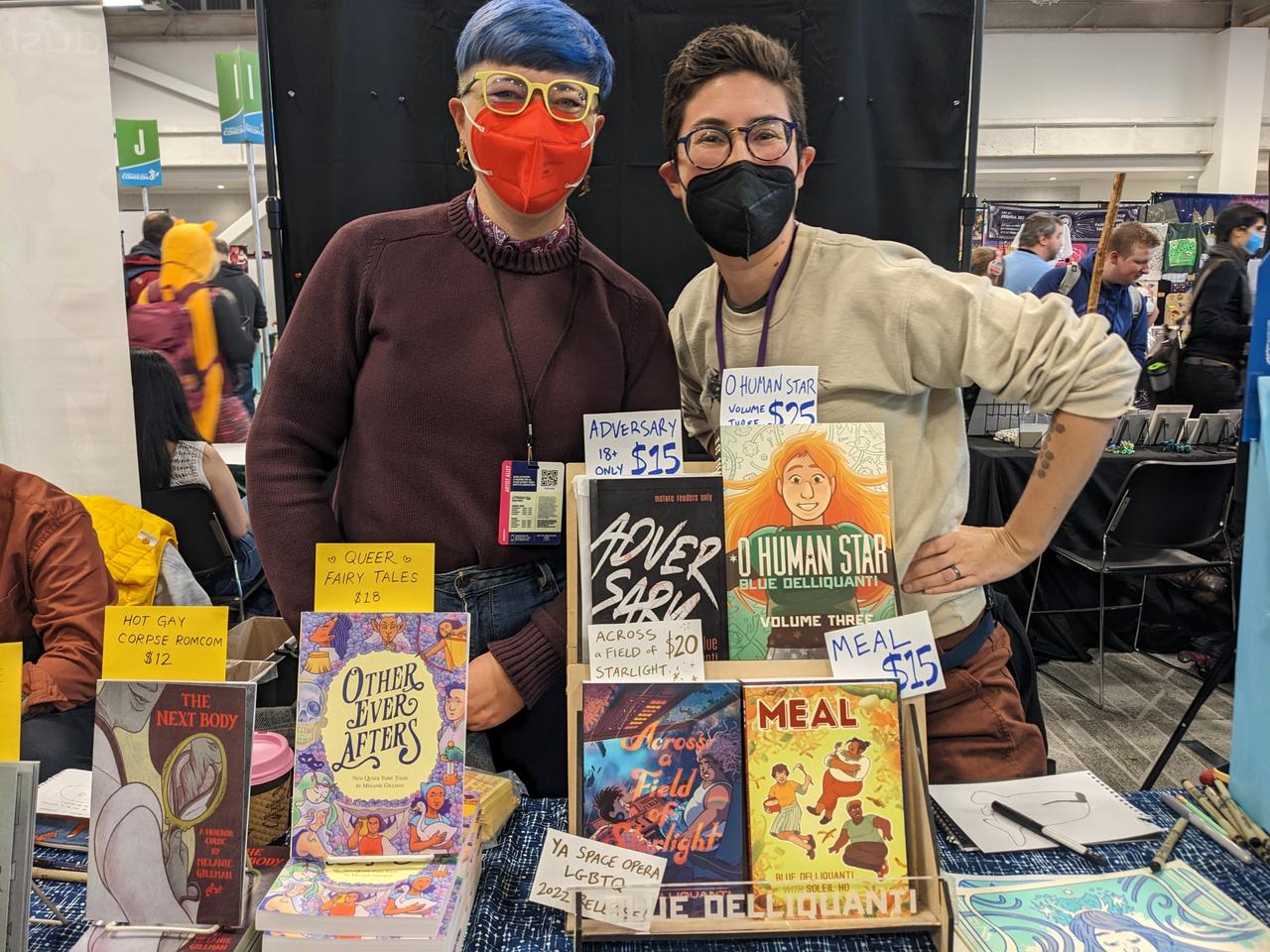 Photograph of two artists behind their table