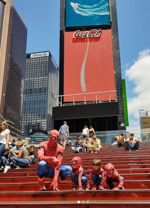 Dan Mora, his two sons, and a nephew dressed as Spider-Man in a city square