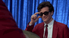 Person behind drum kit pulling down their sunglasses.